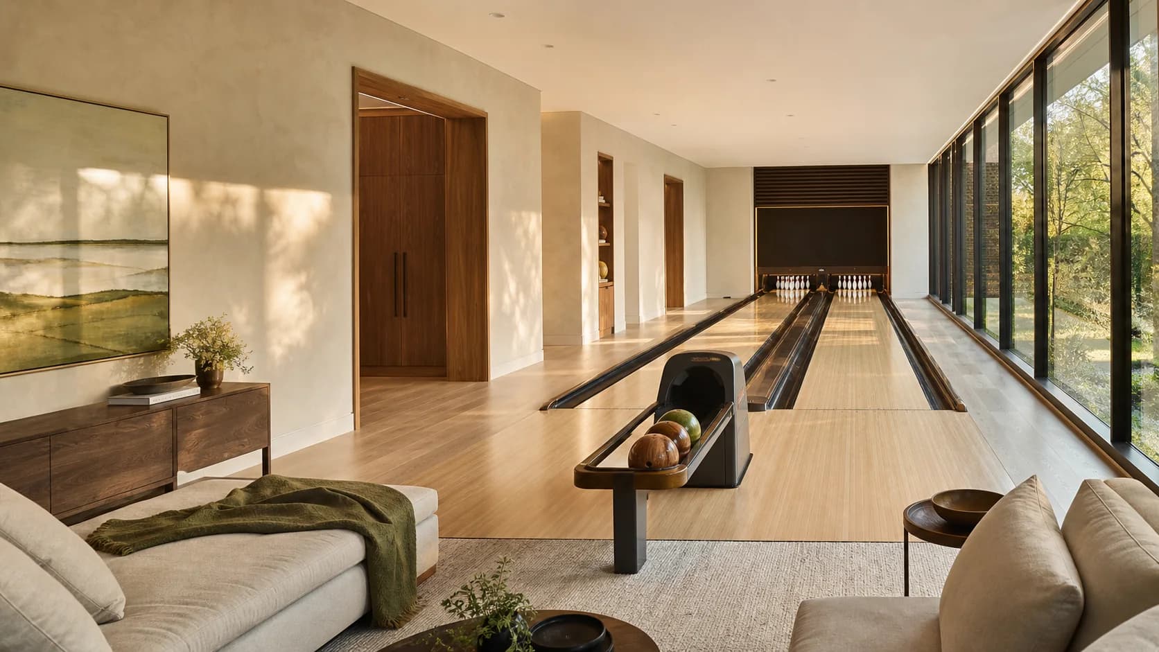 Sunlit private bowling lanes opening onto a comfortable lounge and garden views